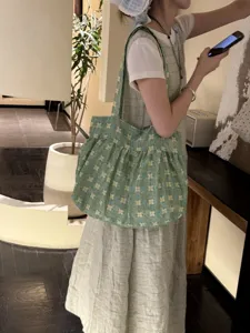 Vista dettagliata della borsa tote floreale verde con texture in tessuto vintage fresco per uso quotidiano.
