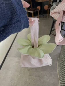 Detailed view of the cute pink polka dot flower drawstring bag, showing petal design and fabric texture.