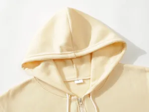 Close-up detail of cozy fleece zip-up hooded sweatshirt collar and drawstring in soft beige.