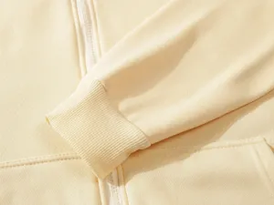 Detailed view of casual fleece zip-up hoodie cuff and zipper, soft solid color fabric.