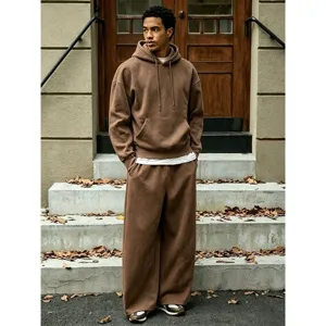 Outdoor street style scene showing details of the brown fleece hoodie and wide-leg pants set.