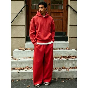 Detail view of men casual fleece hoodie and baggy wide leg sweatpants set in solid red color.