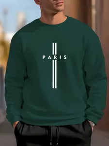 Dark green crewneck sweatshirt detail featuring a bold white Paris cross graphic print.