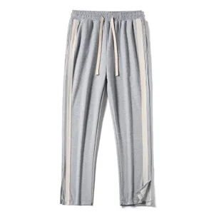 Detail shot of gray casual sweatpants featuring light side stripes, drawstring waist, and split hem.
