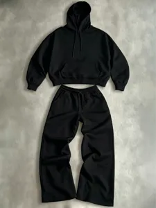 Detail shot of the black hoodie and wide-leg sweatpants, showing soft fabric texture and seams.