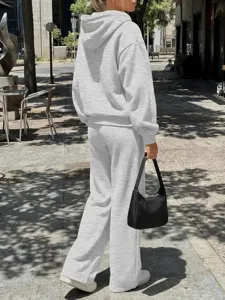 Vista dettagliata di felpa con cappuccio e pantaloni grigi casual all'aperto, comodo abbigliamento.