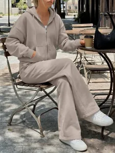 Vista dettagliata della felpa beige con cappuccio e zip e dei pantaloni sportivi all aperto.