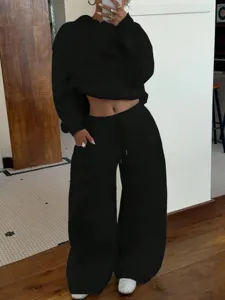 Detail view of women black fleece tracksuit, featuring stylish crop hoodie and wide pants.