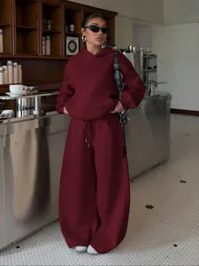 Burgundy fleece hoodie and wide-leg sweatpants set detail in cafe scene, casual streetwear style.