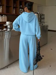 Detail view of light blue fleece hoodie and matching casual sweatpants worn by model.