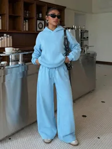 Detail view of light blue fleece hoodie and matching sweatpants set worn in a cozy café setting.