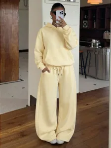 Detail view of women fleece tracksuit set in soft yellow, cozy hoodie and wide leg sweatpants.