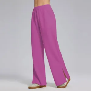 Vista detallada de pantalones de chándal rosa amplios con talle alto y aberturas laterales.