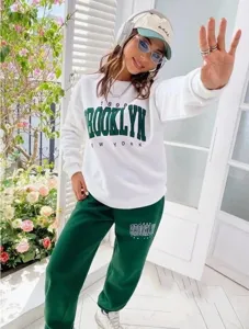 Detailaufnahme eines lässigen weißen Sweatshirts und grünen Jogginghosen Outfits.