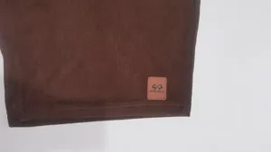 Braune Herren Cordshorts Detailansicht mit einem stilvollen Leder Markenlogo Patch.
