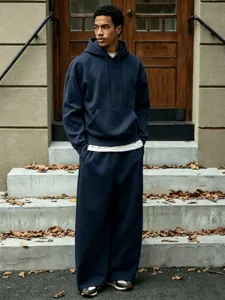 Outdoor detail shot of casual fleece-lined hoodie and wide leg pants tracksuit style.