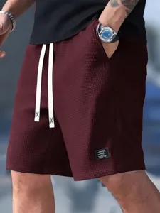 Detailed close-up of men casual waffle textured shorts with drawstring and patch. Perfect fit.
