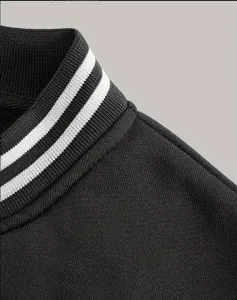 Détail du col de veste de baseball noire pour homme, col côtelé à rayures élégant.