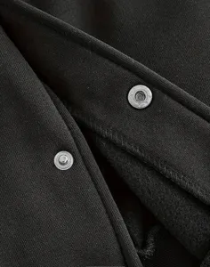 Détail du tissu de veste de baseball pour homme avec boutons-pression et coutures.