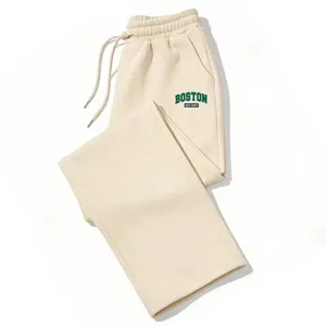 Beige wide leg sweatpants detail shot featuring an elastic drawstring waist and green graphic text.