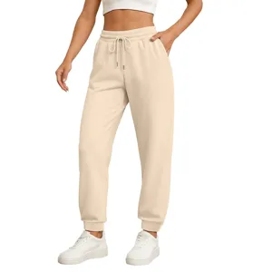 Close-up detail of casual beige sweatpants with elastic drawstring waist and cuffed hem.