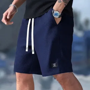 Detail shot of men's waffle knit casual shorts in navy blue with drawstring waist.