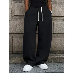 Detail view of men's casual loose black sweatpants with long white drawstrings for streetwear.