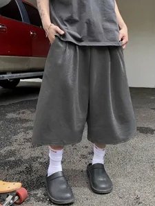 Detailed view of men's solid grey wide leg cropped shorts, casual loose streetwear style.