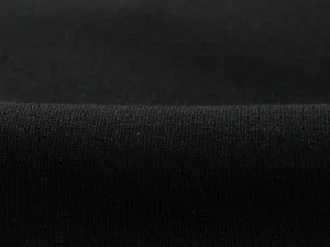 Close-up view of black fleece fabric showing fine texture and soft material detail for pants.