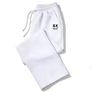 Vista detallada del pantalón blanco holgado con estampado de smiley gótico de ojos en cruz.