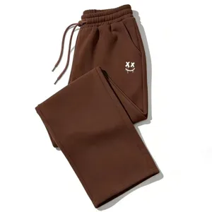 Cómodo pantalón de chándal holgado marrón Y2K con estampado de smiley gótico XX.