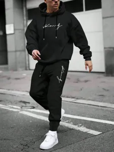 Detail shot of men black hoodie and sweatpants set featuring white cursive script print chest.