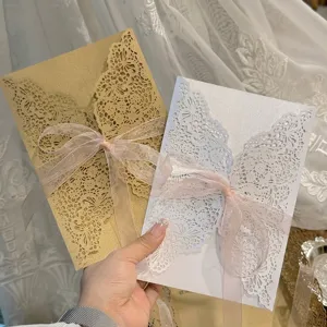 Détail de cartes d'invitation découpées au laser avec rubans de soie rose