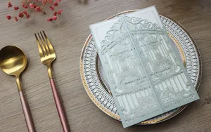 Invitación de boda cortada con láser con detalles en pan de oro en un plato decorativo