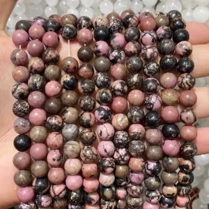 Close-up of pink and black mottled natural rhodonite round beads for jewelry making