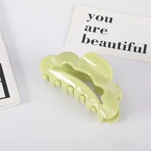 Detailed view of large scalloped acetate hair claw clip in refreshing light green color