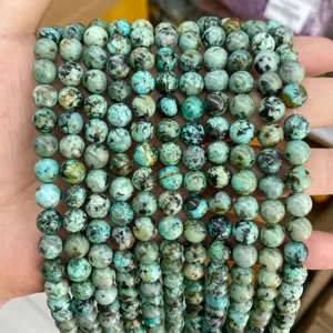 Close-up of round turquoise beads with natural black mineral veins for DIY jewelry