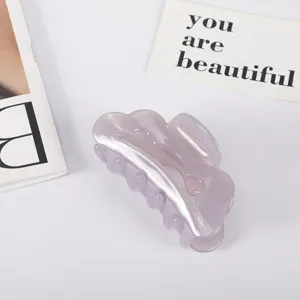 Close-up detail showing the glossy lavender acetate finish and wavy edge of this hair claw clip