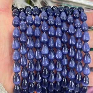 Macro view of 8x12mm blue teardrop cat's eye beads with shimmering light effect.