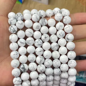 Detailed view of white howlite stone round beads with grey marble patterns for DIY.