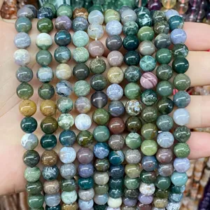 Close-up detail of natural moss agate round beads showing unique green and earthy patterns