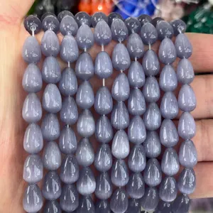 Close-up macro detail of 8x12mm teardrop cat's eye stone beads in greyish purple