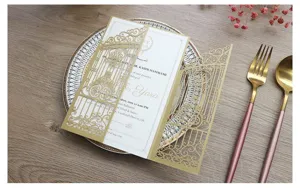 Elegante invitación de boda dorada cortada con láser y motivos florales en relieve.
