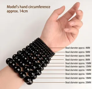 Detailed size comparison of black agate stone beads from 4mm to 20mm on a wrist.