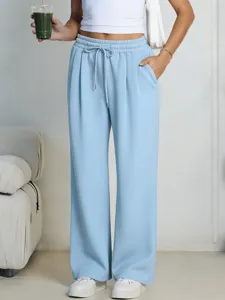 Detailed view of casual light blue wide-leg pants with elastic drawstring waist and side pockets.