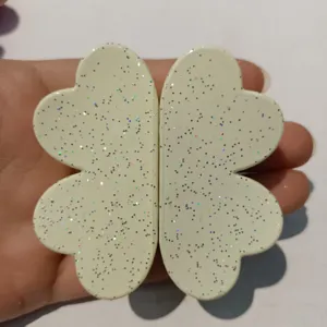 Detailed close-up shot of the clover shaped magnetic hair clip featuring delicate glitter surface.