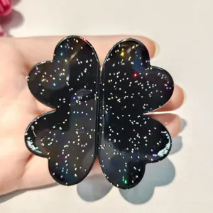 Smart magnetic hair clip with stylish four leaf clover design and glitter finish for use.