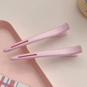 Close-up view of professional pink long duckbill hair clips, seamless sectioning for styling.