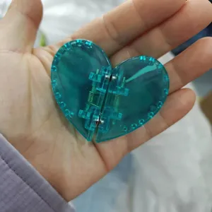 Detailansicht der blauen transparenten herzförmigen magnetischen Haarklammer mit feder.