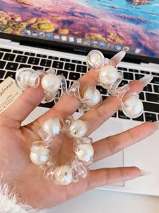 Dettaglio in primo piano di elastico per capelli a spirale trasparente con perle.